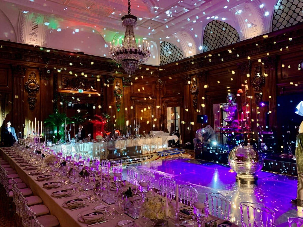 Elegant event hall with a stage for Philippe Harari Sings, featuring luxurious wood paneling, a gran.